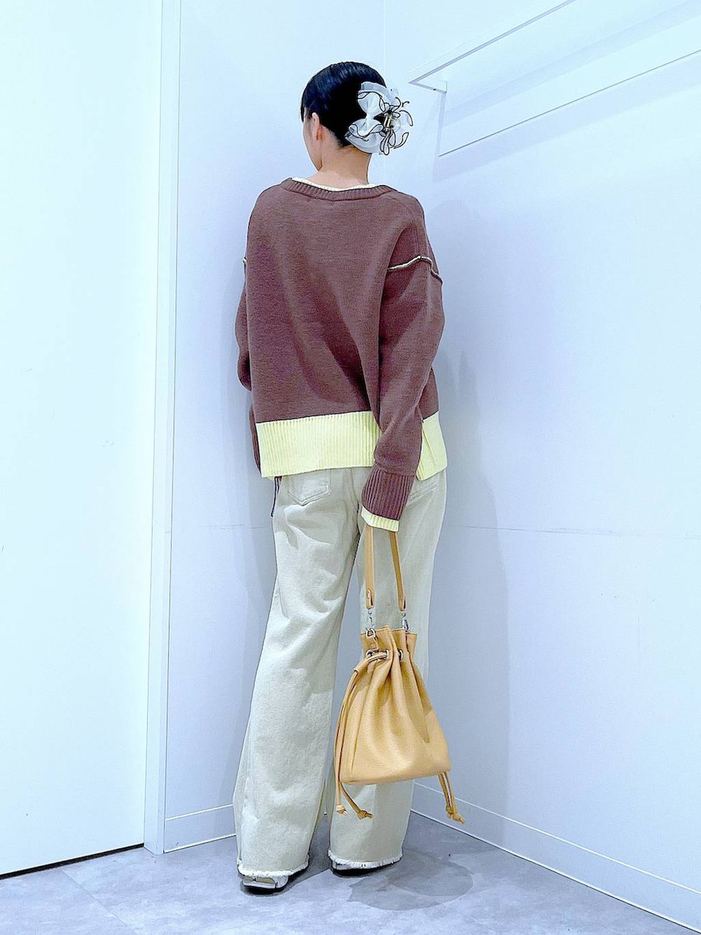 ブラウン系のニット/セーター、ベージュ系のデニムパンツ、ブラウン系のショルダーバッグを着用したレディースの冬コーディネートの5枚目の写真