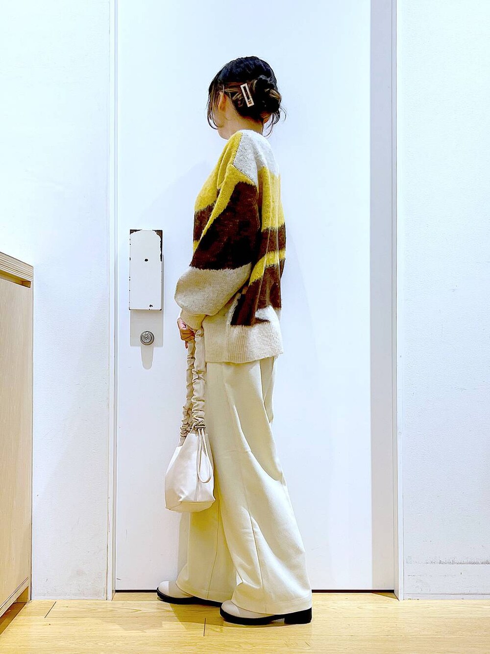 ホワイト系のショルダーバッグ、ベージュ系のブーツ、ベージュ系のその他パンツを着用したレディースの冬コーディネートの3枚目の写真