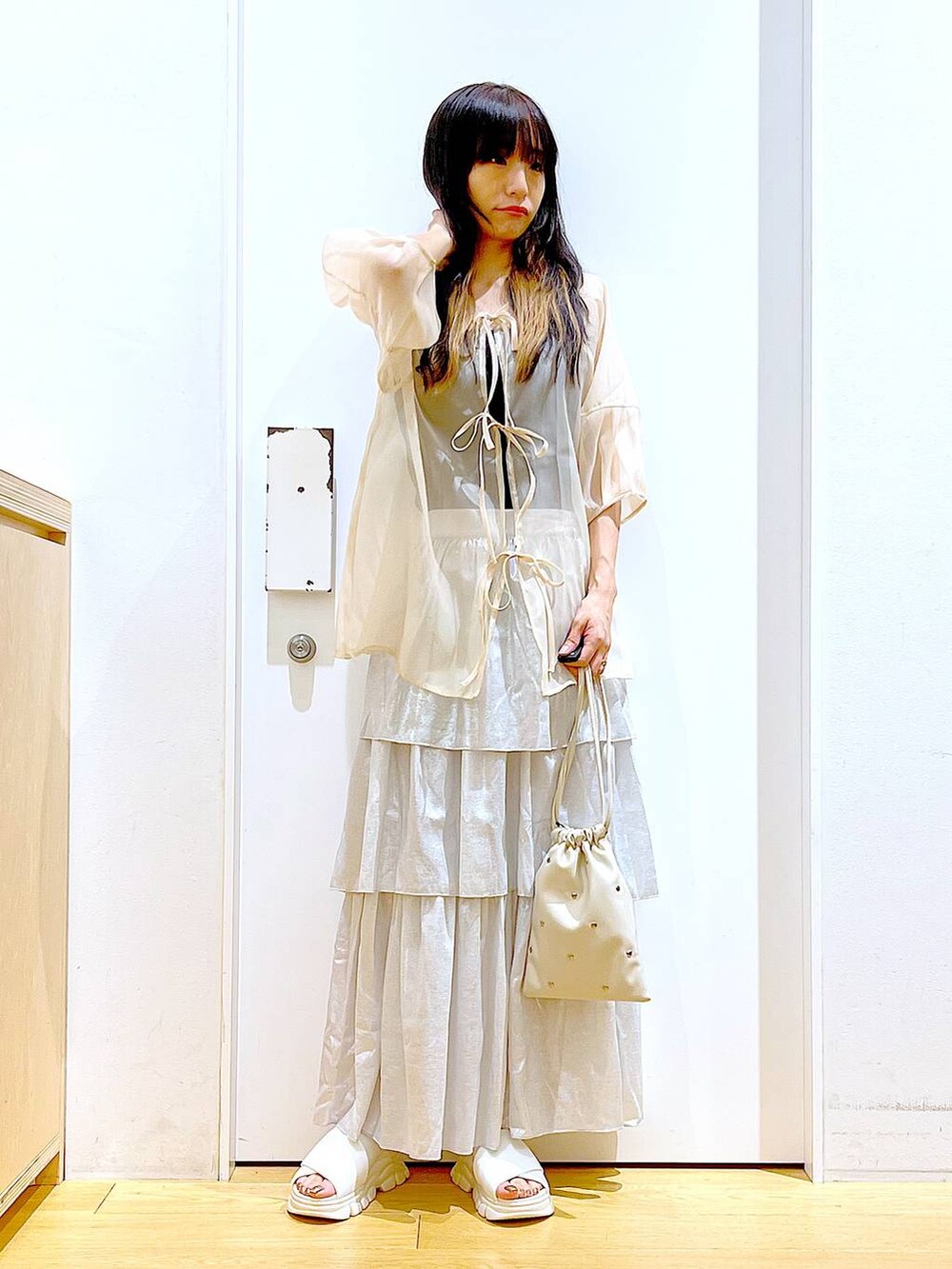 ホワイト系のサンダル、ブラック系のニット/セーター、ホワイト系のショルダーバッグを着用したレディースの夏コーディネートの2枚目の写真