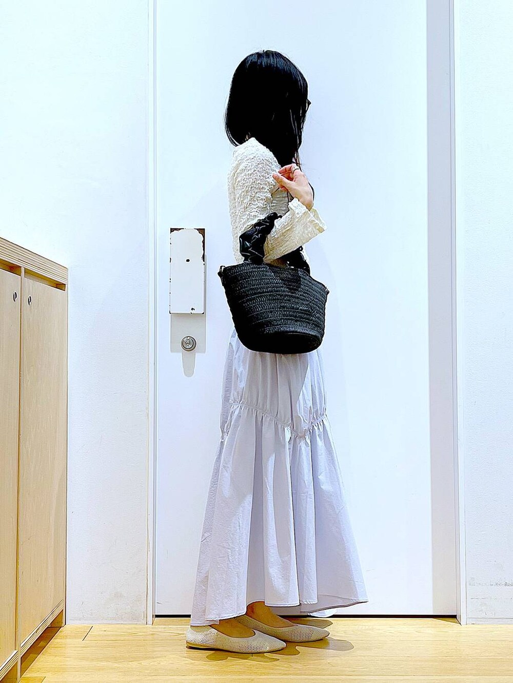 ホワイト系のカーディガン/ボレロ、イエロー系のニット/セーター、ホワイト系のパンプスを着用したレディースの春コーディネートの4枚目の写真