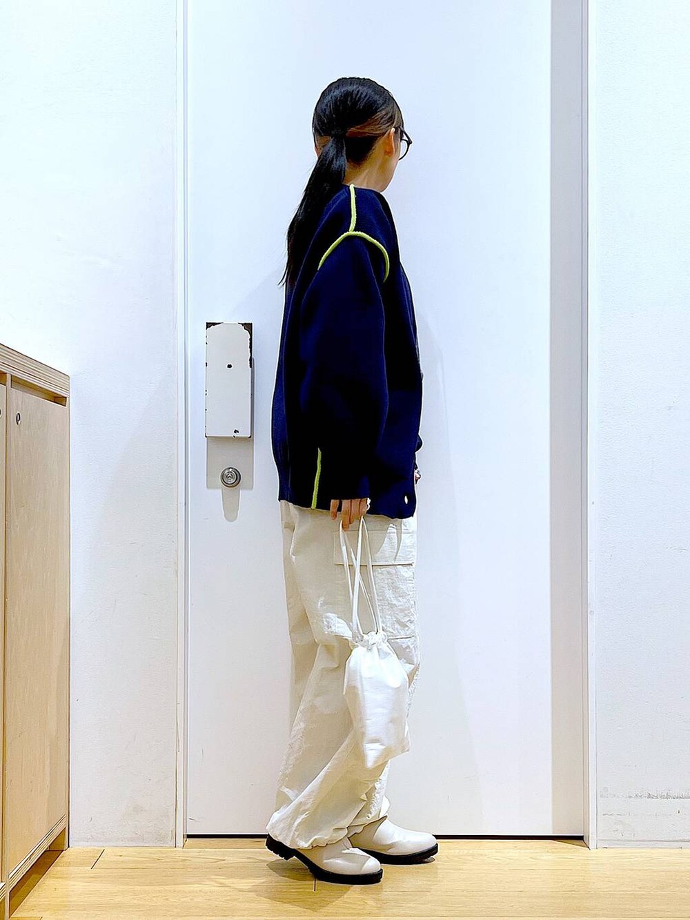 グレー系のTシャツ/カットソー、ベージュ系のブーツ、ホワイト系のショルダーバッグを着用したレディースの冬コーディネートの4枚目の写真