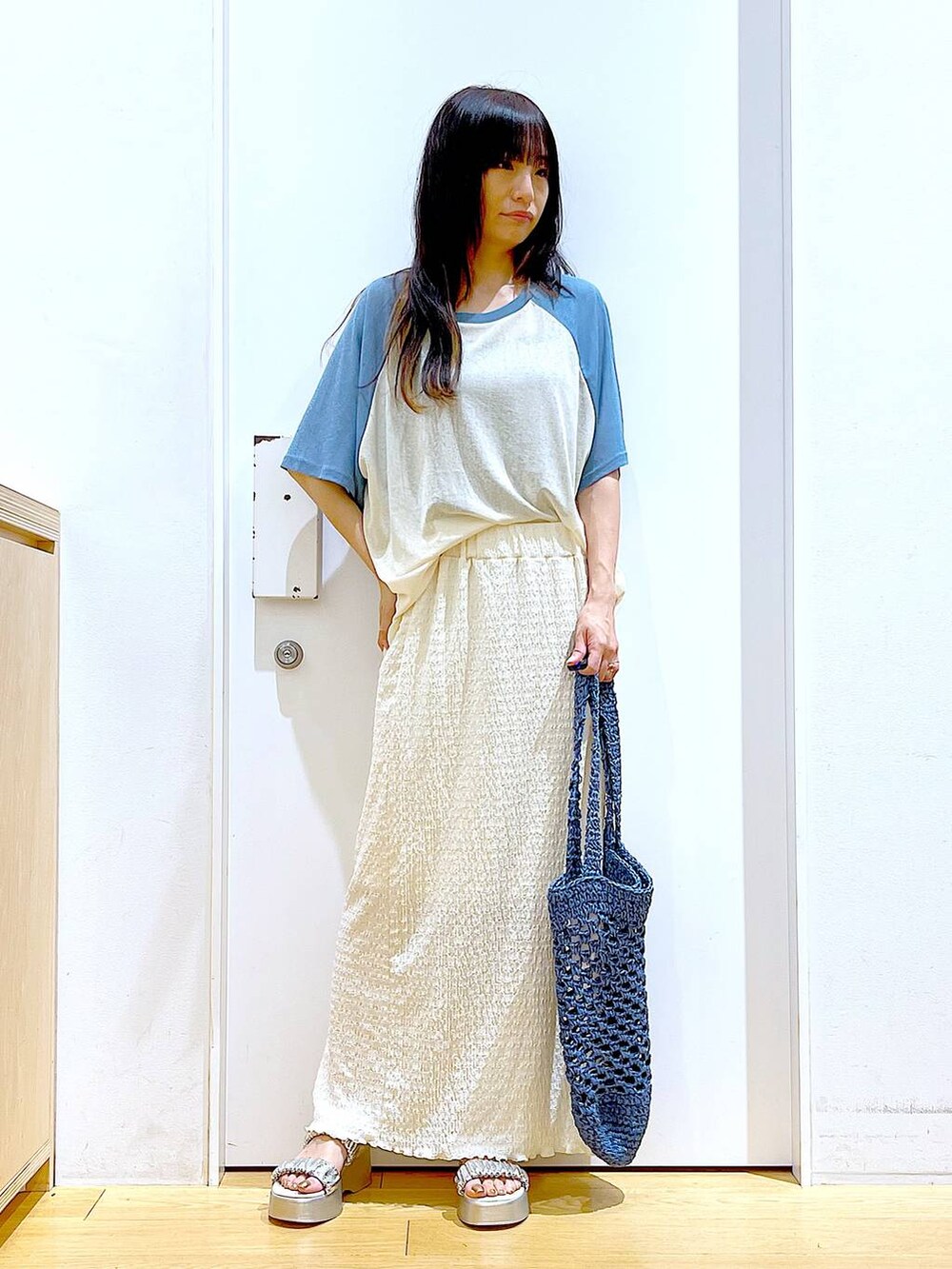 シルバー系のサンダル、ブルー系のトートバッグ、ベージュ系のスカートを着用したレディースの夏コーディネートの2枚目の写真