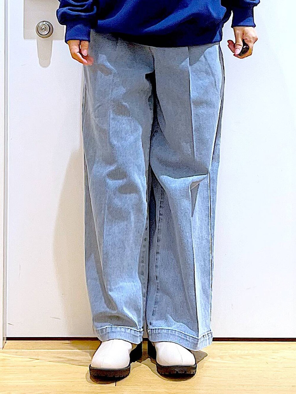 ブルー系のデニムパンツ、ブルー系のスウェット、ベージュ系のブーツを着用したレディースの春コーディネートの8枚目の写真