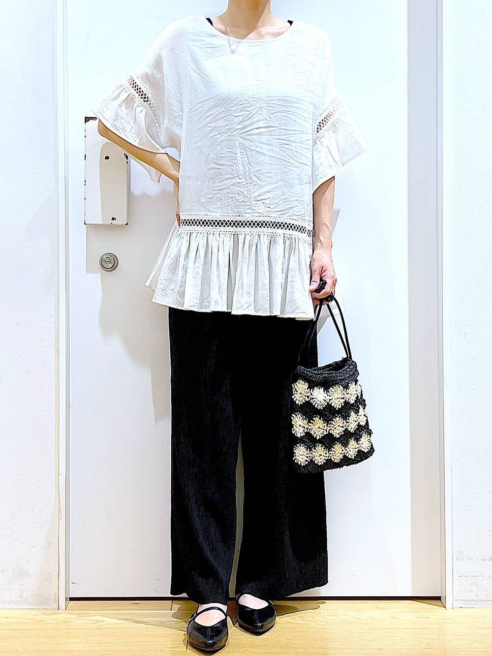 ホワイト系のチュニック、ブラック系のその他パンツ、ブラック系のパンプスを着用したレディースの夏コーディネートの6枚目の写真