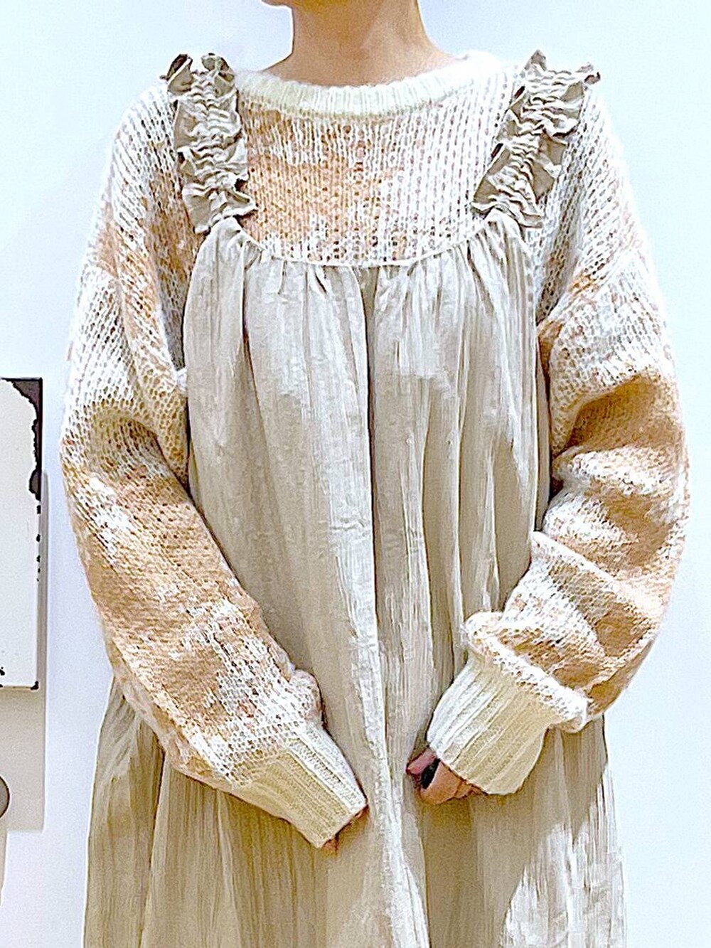 ブラック系のショルダーバッグ、ブラック系のブーツ、ベージュ系のワンピースを着用したレディースの冬コーディネートの7枚目の写真