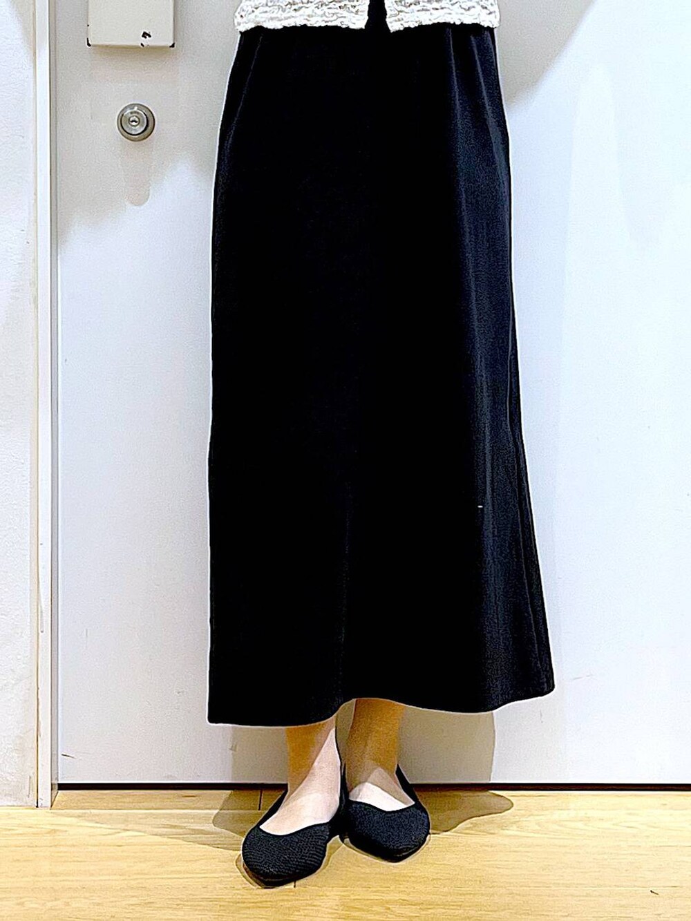 ブルー系のショルダーバッグ、ブラック系のパンプス、ブラック系のワンピースを着用したレディースの春コーディネートの8枚目の写真