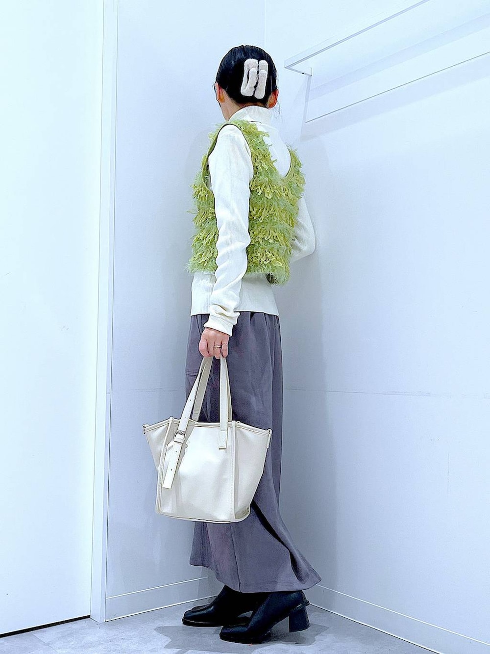 ブラック系のブーツ、グレー系のスカート、ベージュ系のニット/セーターを着用したレディースの冬コーディネートの3枚目の写真