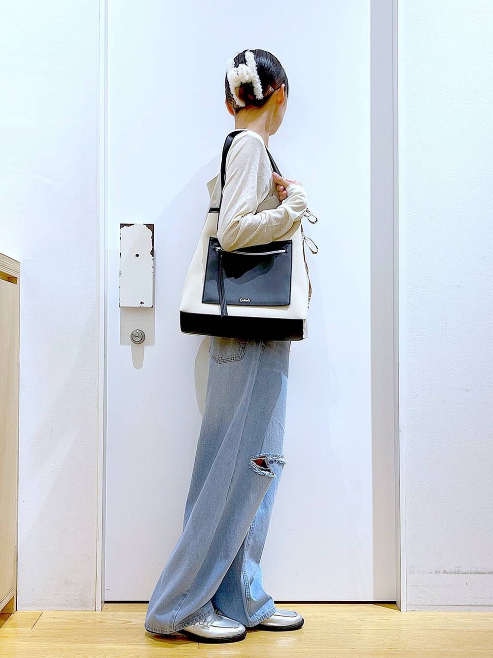 ブルー系のデニムパンツ、シルバー系のローファー、ホワイト系のトートバッグを着用したレディースの秋コーディネートの4枚目の写真