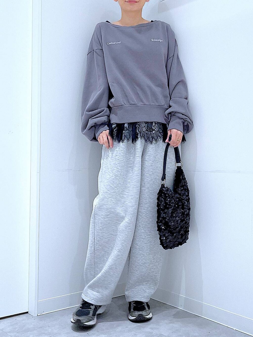 グレー系のスウェット、ブラック系のショルダーバッグ、ブラック系のタンクトップを着用したレディースの春コーディネートの6枚目の写真
