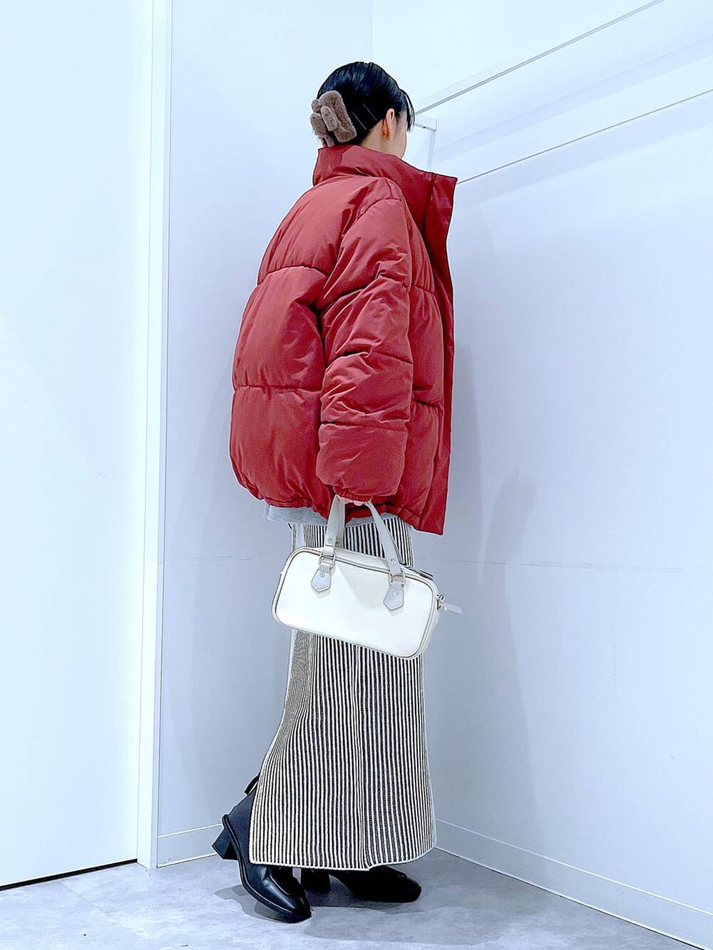 ブラウン系のブルゾン、ベージュ系のスカート、ブラック系のブーツを着用したレディースの冬コーディネートの4枚目の写真