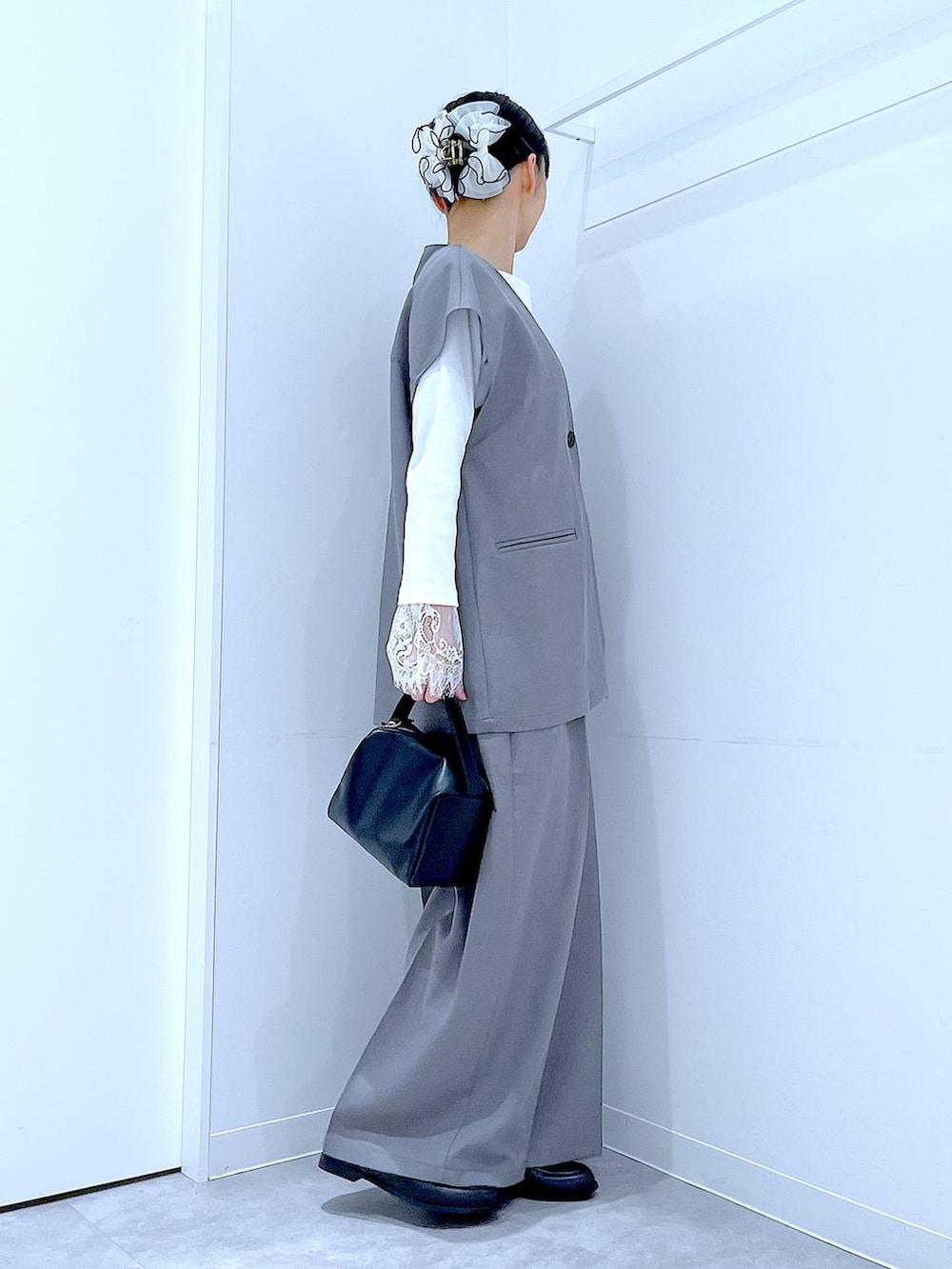 ブラック系のショルダーバッグ、グレー系のサロペット/オーバーオール、グレー系のベストを着用したレディースの冬コーディネートの4枚目の写真