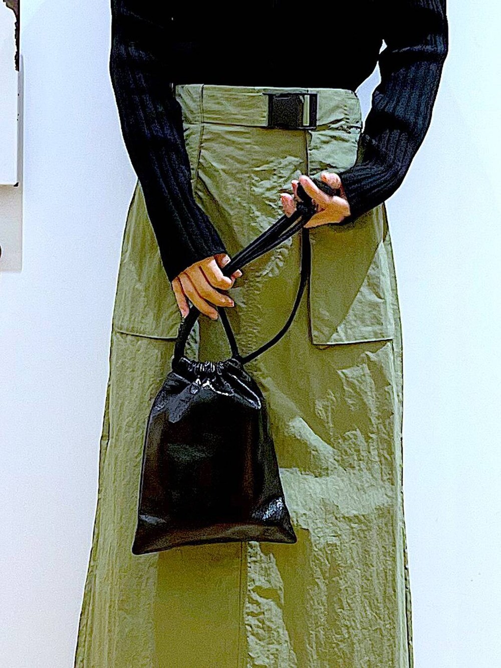 ブラック系のカーディガン/ボレロ、ベージュ系のブーツ、ブラック系のショルダーバッグを着用したレディースの春コーディネートの9枚目の写真