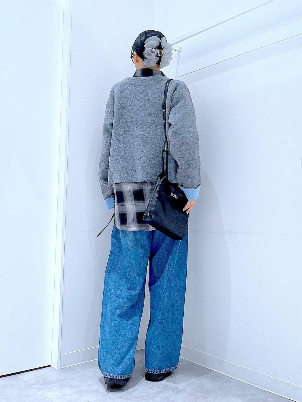 ブルー系のデニムパンツ、ブラック系のシャツ/ブラウス、ブラック系のショルダーバッグを着用したレディースの秋コーディネートの5枚目の写真