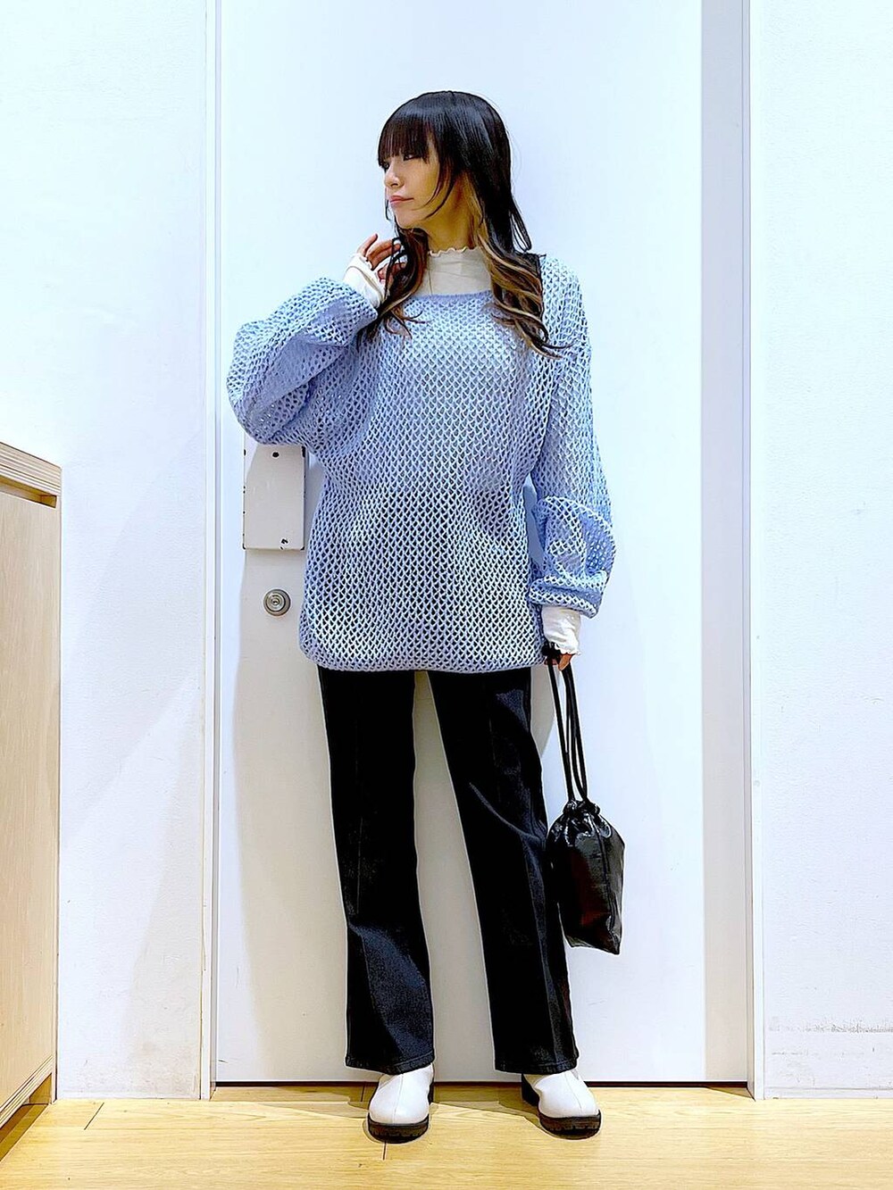 グレー系のデニムパンツ、ホワイト系のTシャツ/カットソー、ブルー系のニット/セーターを着用したレディースの冬コーディネートの2枚目の写真