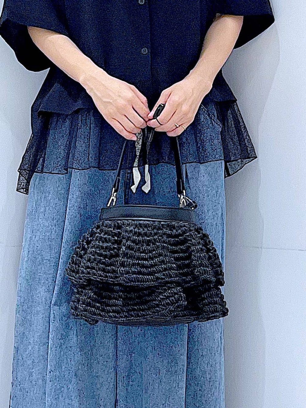 ブラック系のショルダーバッグ、ブラック系のサンダル、ブルー系のデニムパンツを着用したレディースの夏コーディネートの9枚目の写真