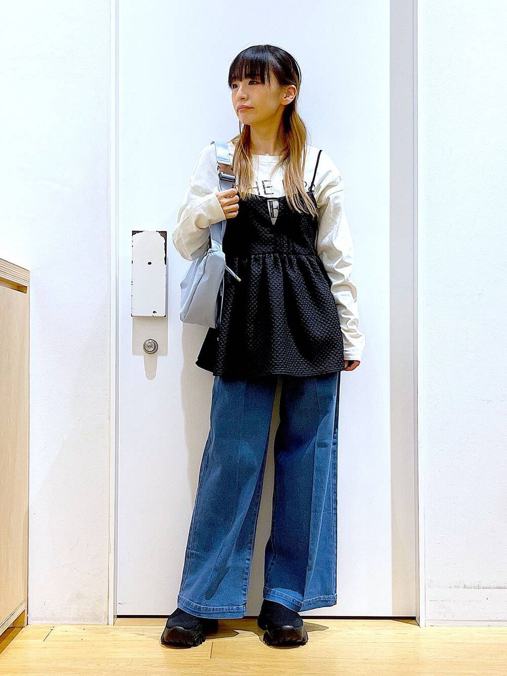 ブルー系のデニムパンツ、ホワイト系のTシャツ/カットソー、ブルー系のショルダーバッグを着用したレディースの春コーディネートの2枚目の写真