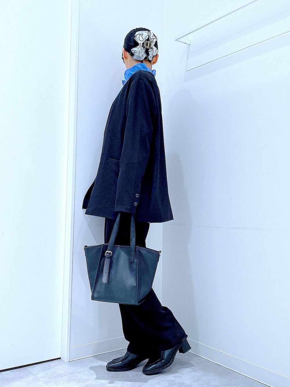 ブラック系のブーツ、ブラック系のトートバッグ、ブラック系のノーカラージャケットを着用したレディースの冬コーディネートの3枚目の写真