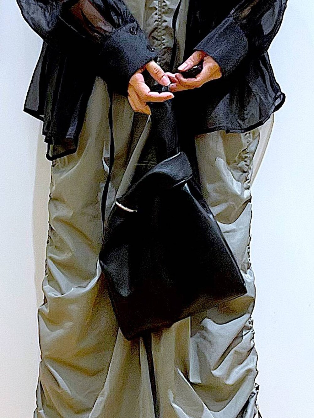 ブラック系のショルダーバッグ、ブラック系のパンプス、グリーン系のワンピースを着用したレディースの春コーディネートの9枚目の写真