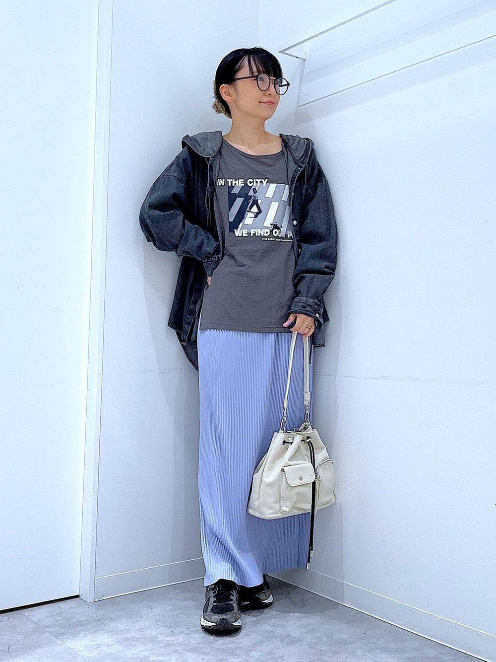 ホワイト系のショルダーバッグ、パープル系のスカート、グレー系のTシャツ/カットソーを着用したレディースの春コーディネートの2枚目の写真