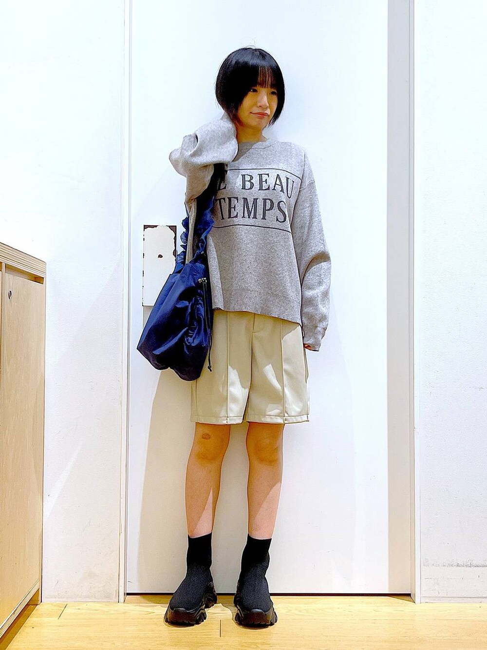 ブルー系のショルダーバッグ、ブラック系のブーツ、ベージュ系のその他パンツを着用したレディースの冬コーディネートの2枚目の写真