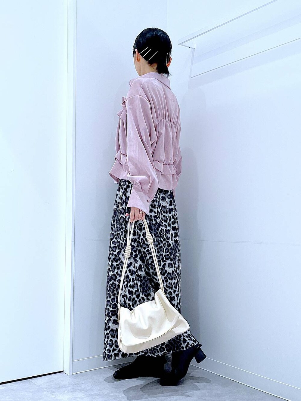 ホワイト系のショルダーバッグ、ブラック系のブーツ、グレー系のスカートを着用したレディースの秋コーディネートの3枚目の写真