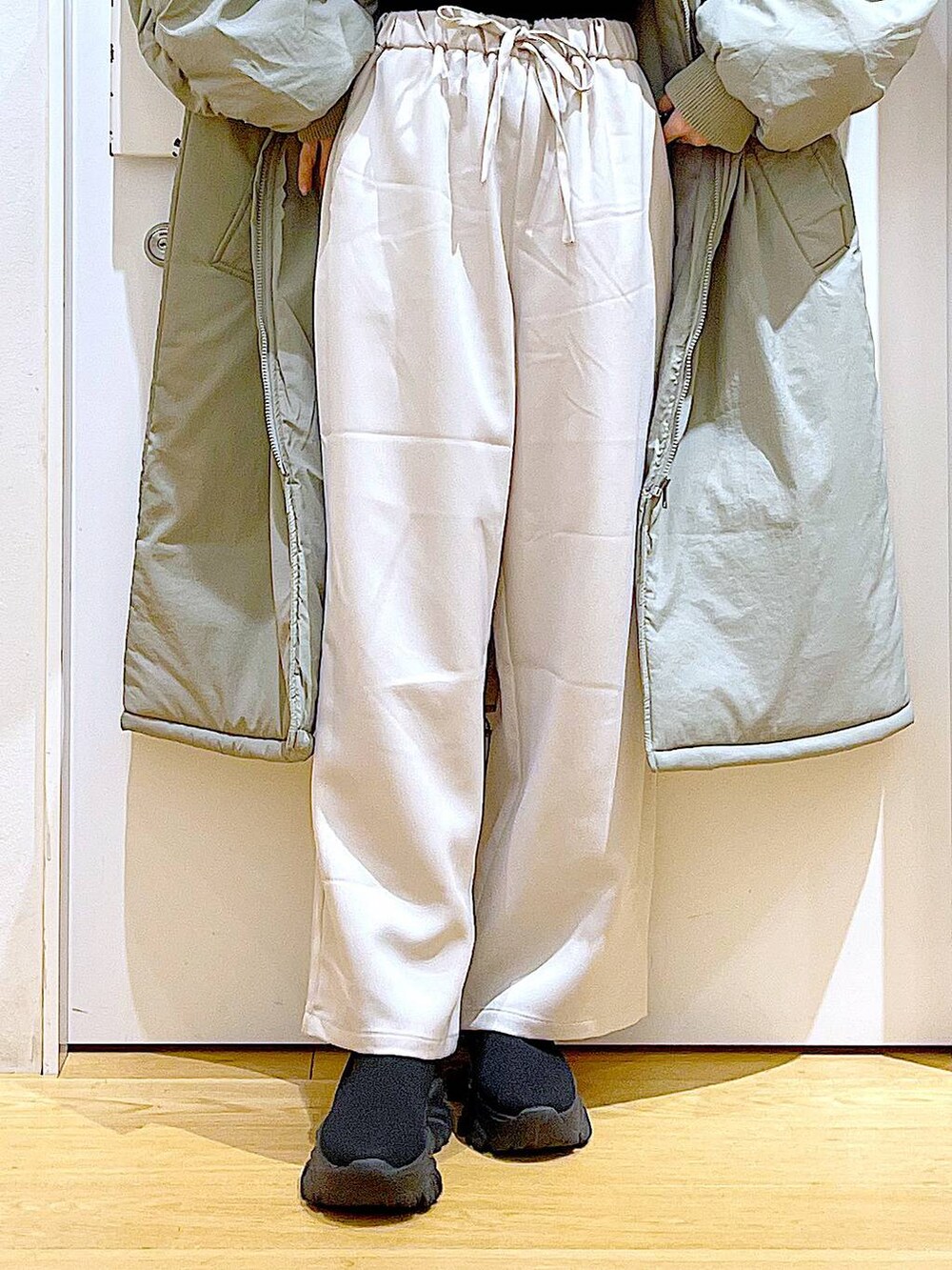 ブラック系のニット/セーター、ベージュ系のショルダーバッグ、ブラック系のブーツを着用したレディースの冬コーディネートの8枚目の写真