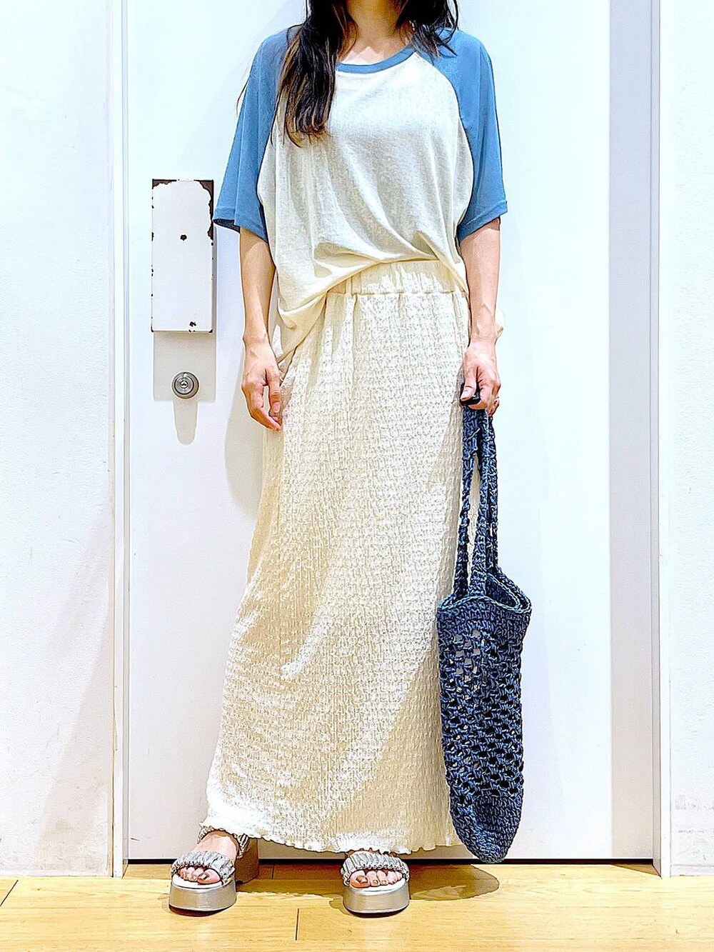 シルバー系のサンダル、ブルー系のトートバッグ、ベージュ系のスカートを着用したレディースの夏コーディネートの6枚目の写真