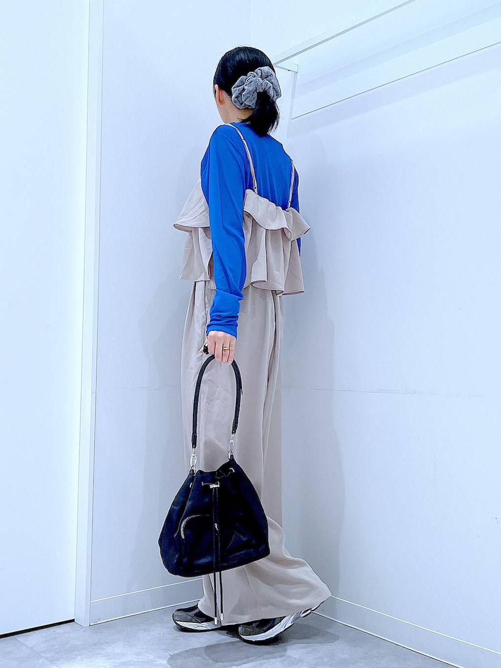 ベージュ系のサロペット/オーバーオール、ブラック系のショルダーバッグ、グレー系のシュシュを着用したレディースの春コーディネートの3枚目の写真