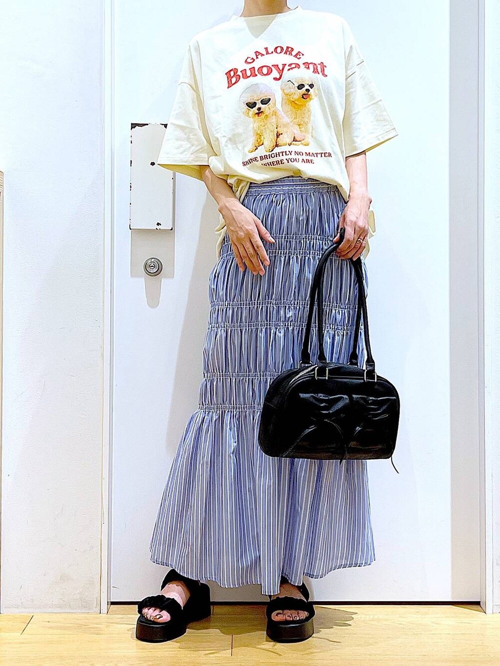 ブラック系のサンダル、その他のスカート、ブラック系のハンドバッグを着用したレディースの夏コーディネートの6枚目の写真