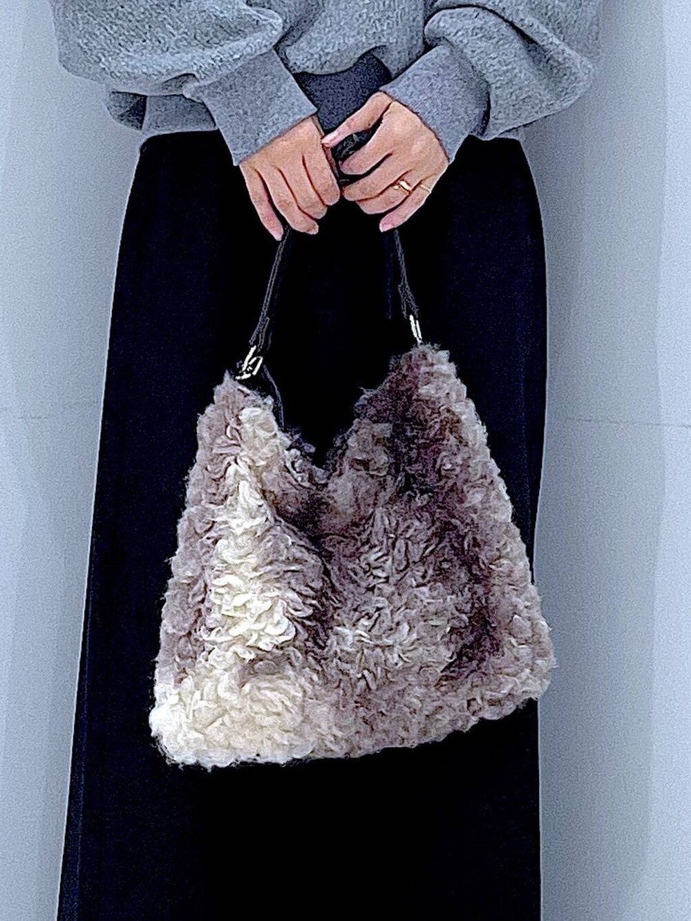 ブラック系のスカート、ブラック系のブーツ、ブラウン系のショルダーバッグを着用したレディースの冬コーディネートの9枚目の写真