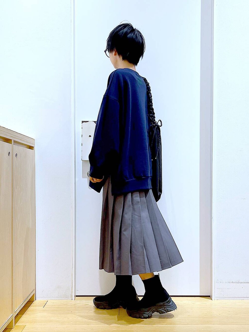 ブラック系のショルダーバッグ、ブラック系のブーツ、グレー系のスカートを着用したレディースの冬コーディネートの3枚目の写真