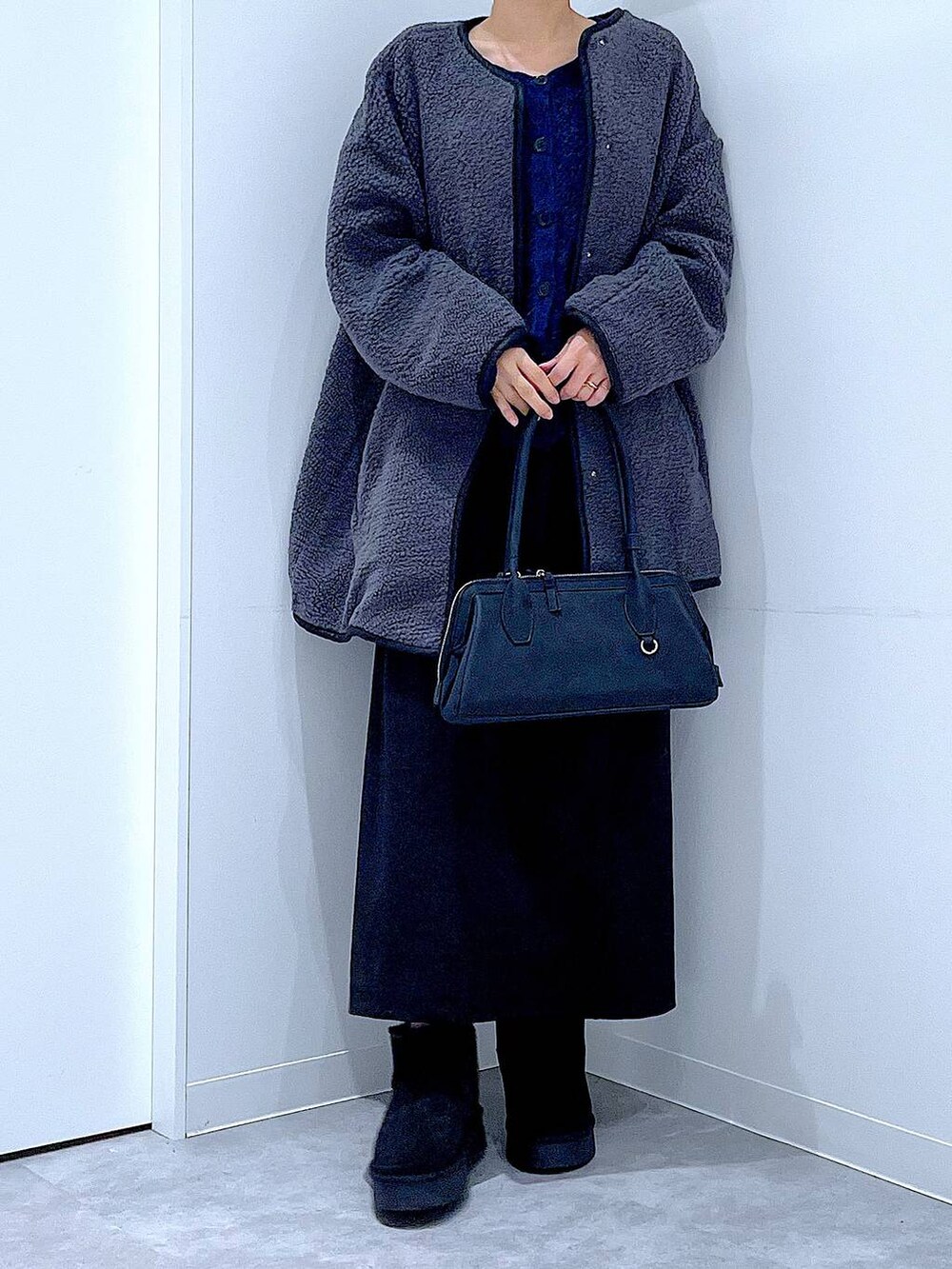 ブラック系のスカート、グレー系のブルゾン、ブラック系のブーツを着用したレディースの秋コーディネートの6枚目の写真