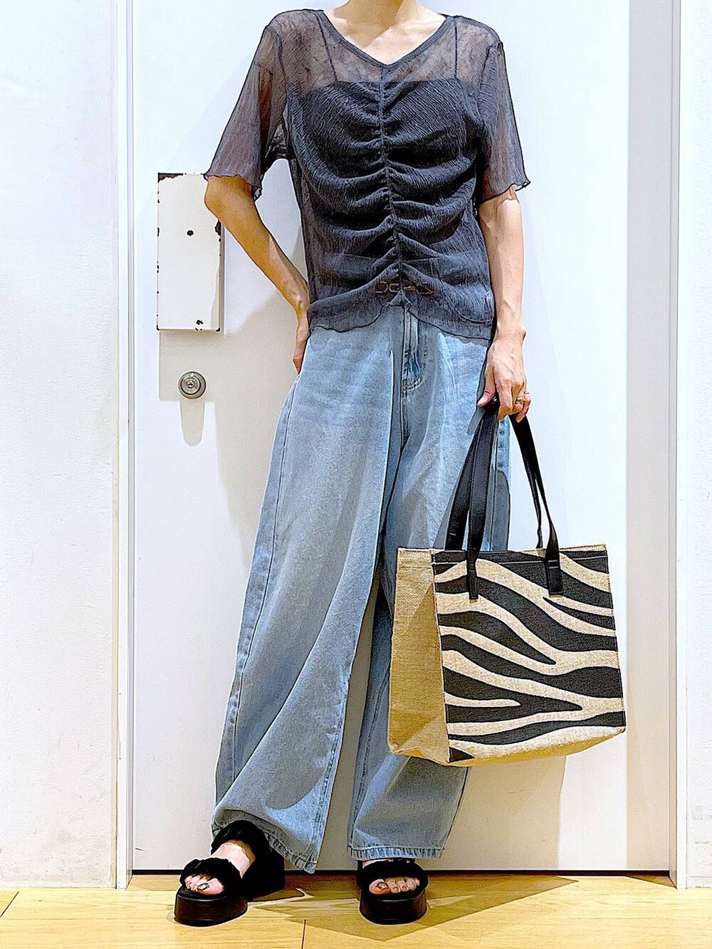 ブルー系のデニムパンツ、その他のトートバッグ、ブラック系のサンダルを着用したレディースの夏コーディネートの6枚目の写真