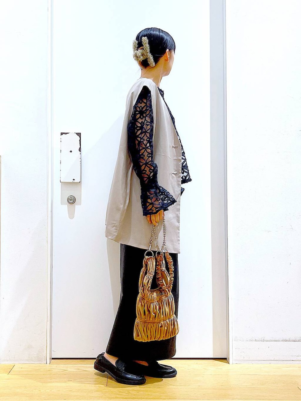 ブラック系のスカート、ブラック系のローファー、ベージュ系のベストを着用したレディースの秋コーディネートの4枚目の写真