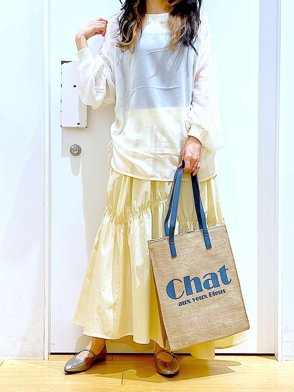 その他のパンプス、ブルー系のトートバッグ、ベージュ系のその他トップスを着用したレディースの春コーディネートの6枚目の写真