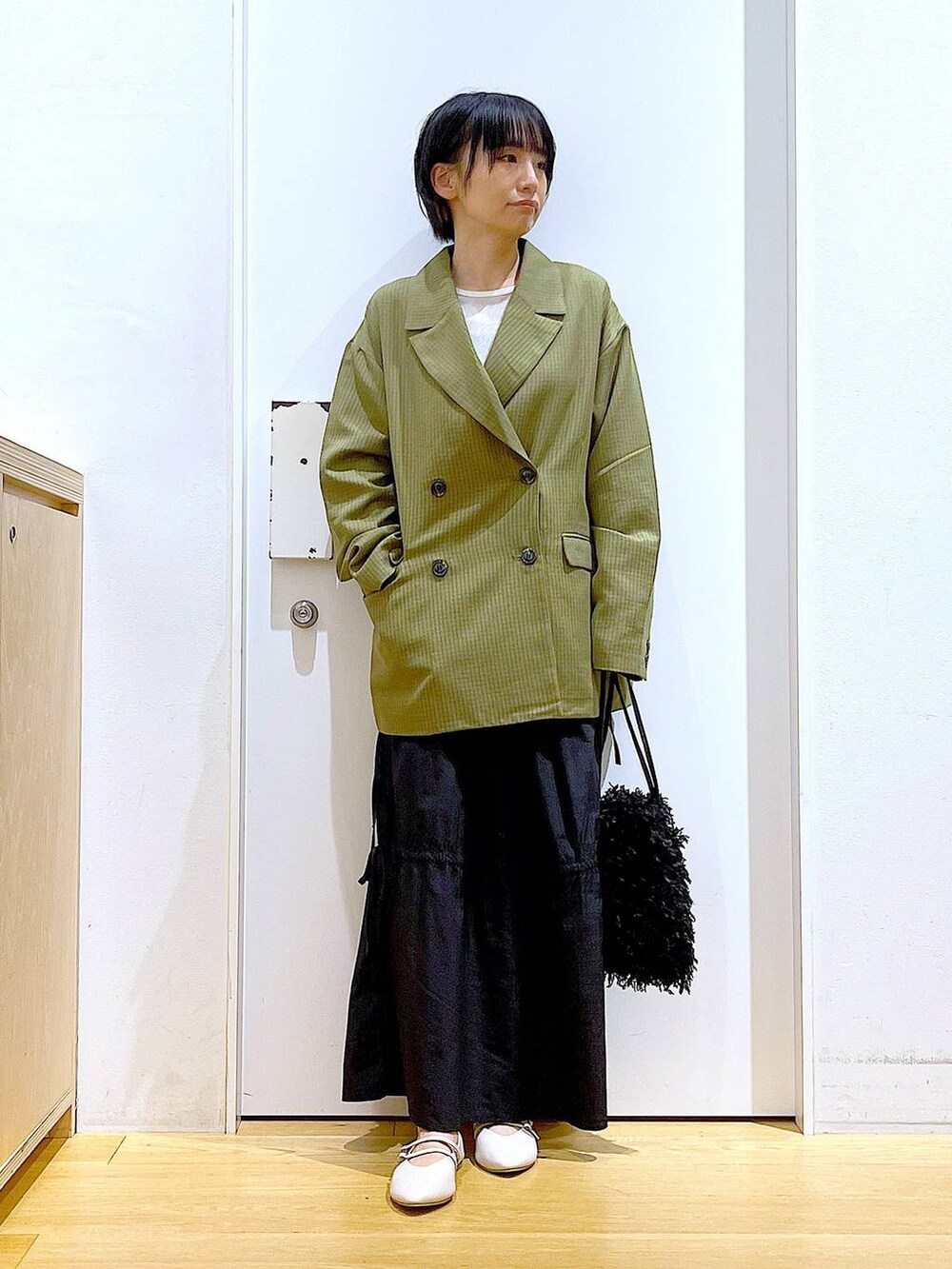 ブラック系のショルダーバッグ、ホワイト系のパンプス、ホワイト系のTシャツ/カットソーを着用したレディースの秋コーディネートの2枚目の写真