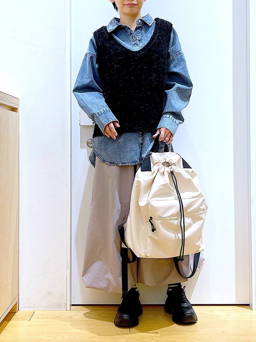 ブルー系のシャツ/ブラウス、ブラック系のスニーカー、ホワイト系のバックパック/リュックを着用したレディースの春コーディネートの6枚目の写真