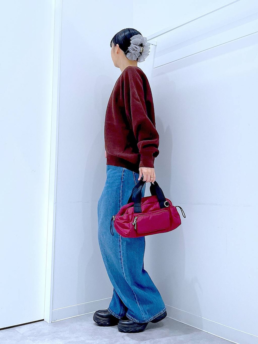 ブルー系のデニムパンツ、ブラウン系のニット/セーター、ブラック系のローファーを着用したレディースの秋コーディネートの3枚目の写真