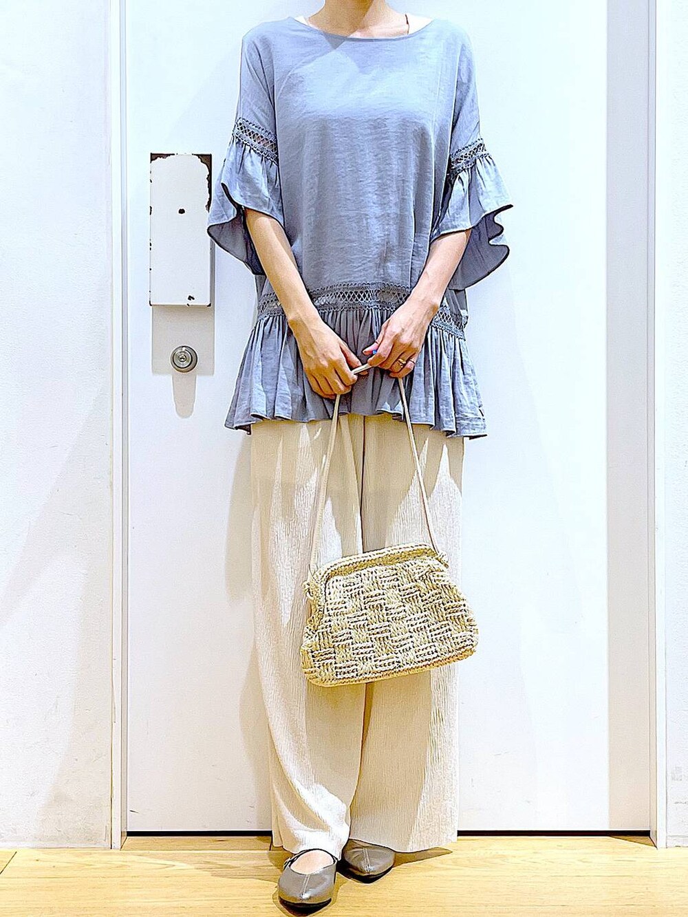 ブルー系のチュニック、その他のパンプス、ホワイト系のショルダーバッグを着用したレディースの春コーディネートの6枚目の写真