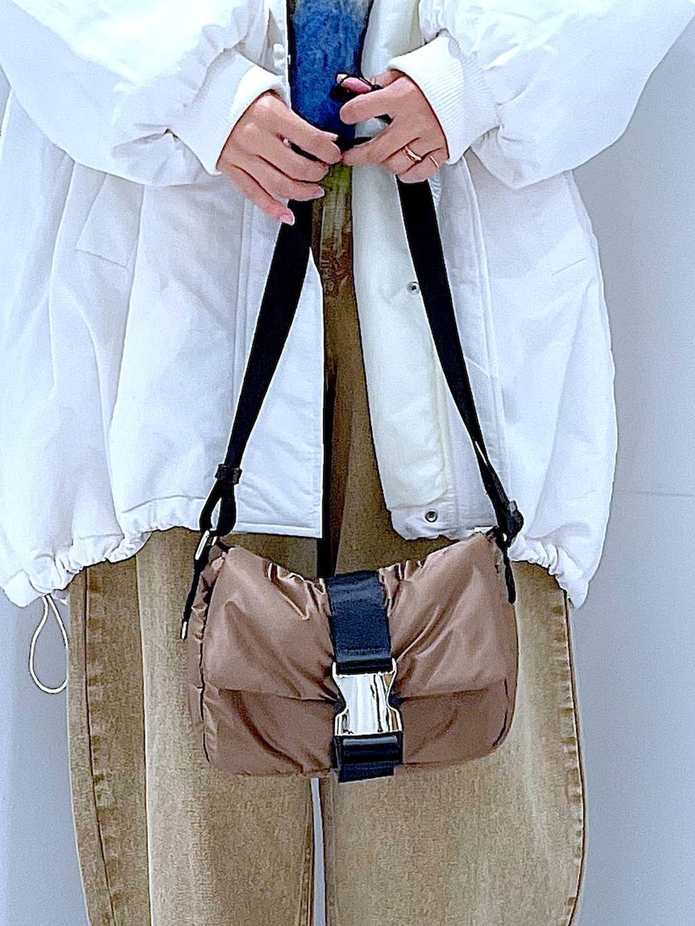 ベージュ系のデニムパンツ、ホワイト系のブルゾン、ブラック系のブーツを着用したレディースの冬コーディネートの9枚目の写真