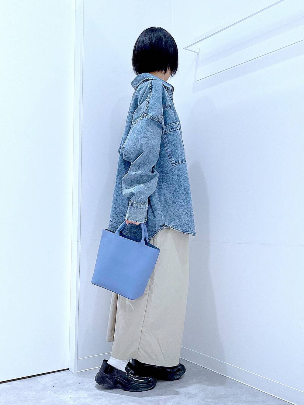 ブルー系のシャツ/ブラウス、ブルー系のショルダーバッグ、ブラック系のローファーを着用したレディースの秋コーディネートの4枚目の写真