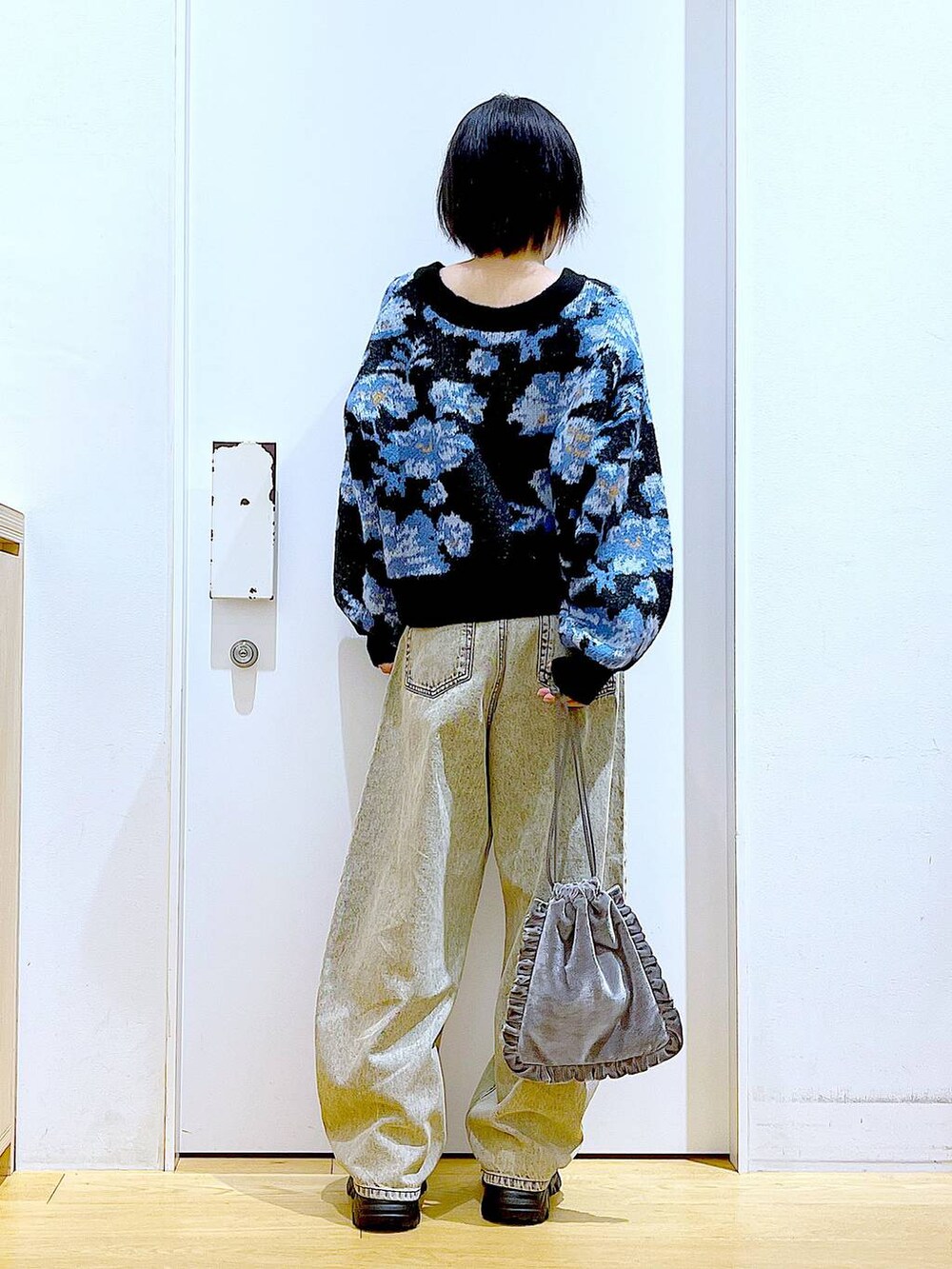 ブラック系のブーツ、グレー系のショルダーバッグ、ベージュ系のデニムパンツを着用したレディースの秋コーディネートの5枚目の写真