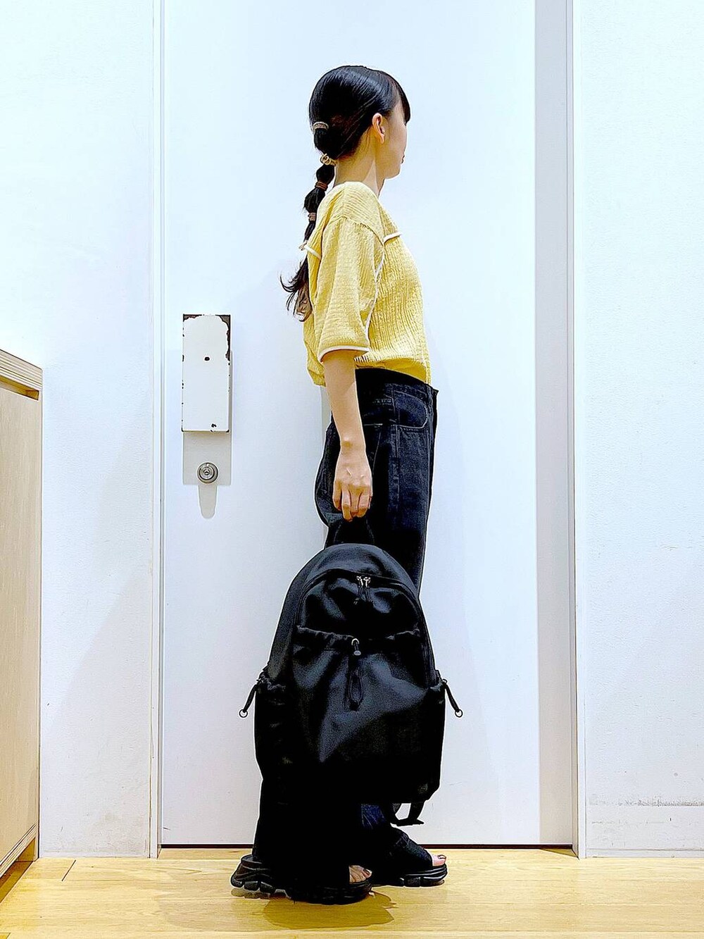 ブラック系のサンダル、ブラック系のバックパック/リュック、ブラック系のデニムパンツを着用したレディースの夏コーディネートの4枚目の写真