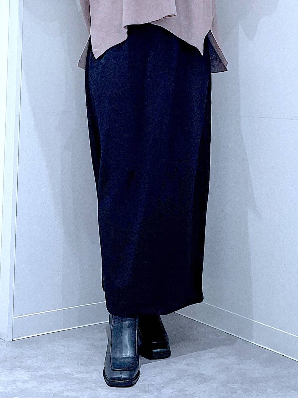 ブラック系のスカート、ブラウン系のニット/セーター、ブラック系のブーツを着用したレディースの秋コーディネートの8枚目の写真