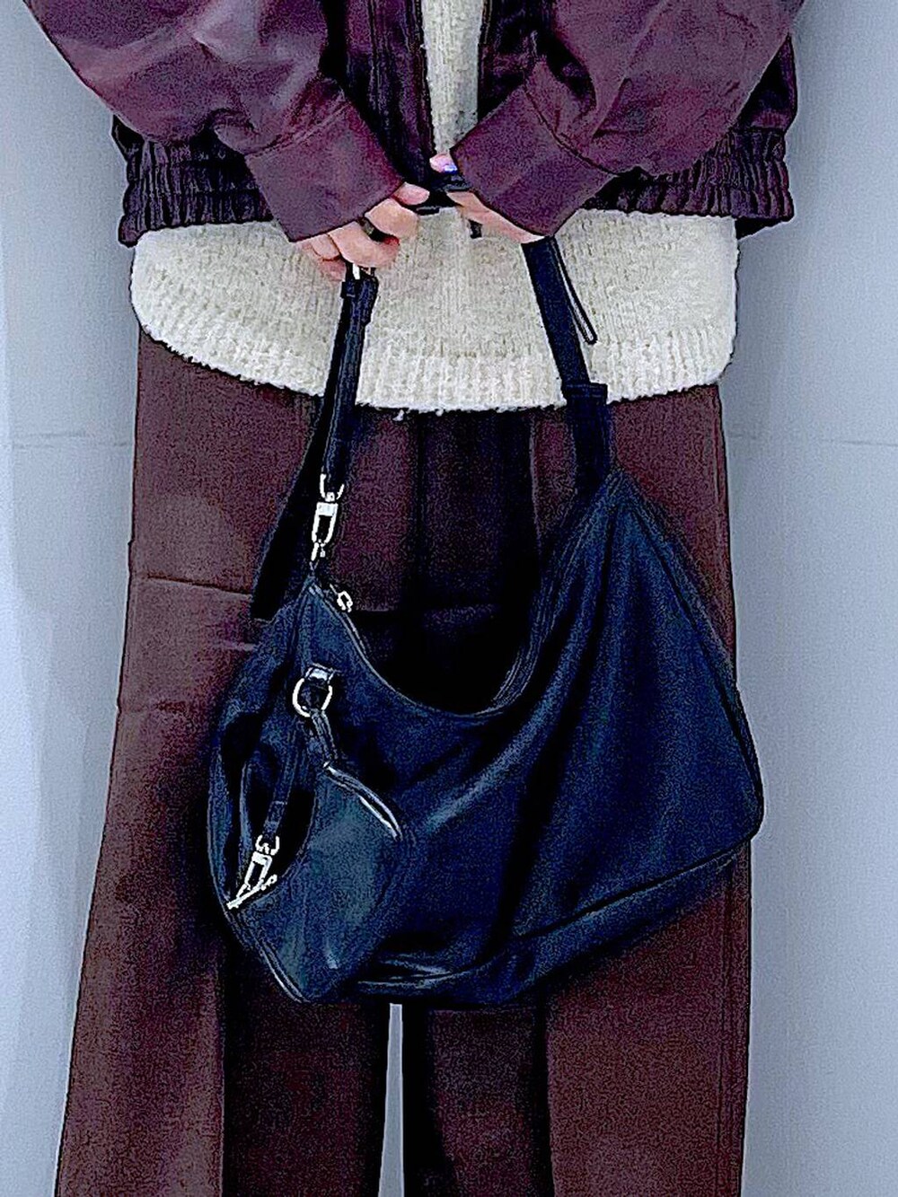 レッド系のブルゾン、ホワイト系のニット/セーター、ブラック系のブーツを着用したレディースの秋コーディネートの9枚目の写真