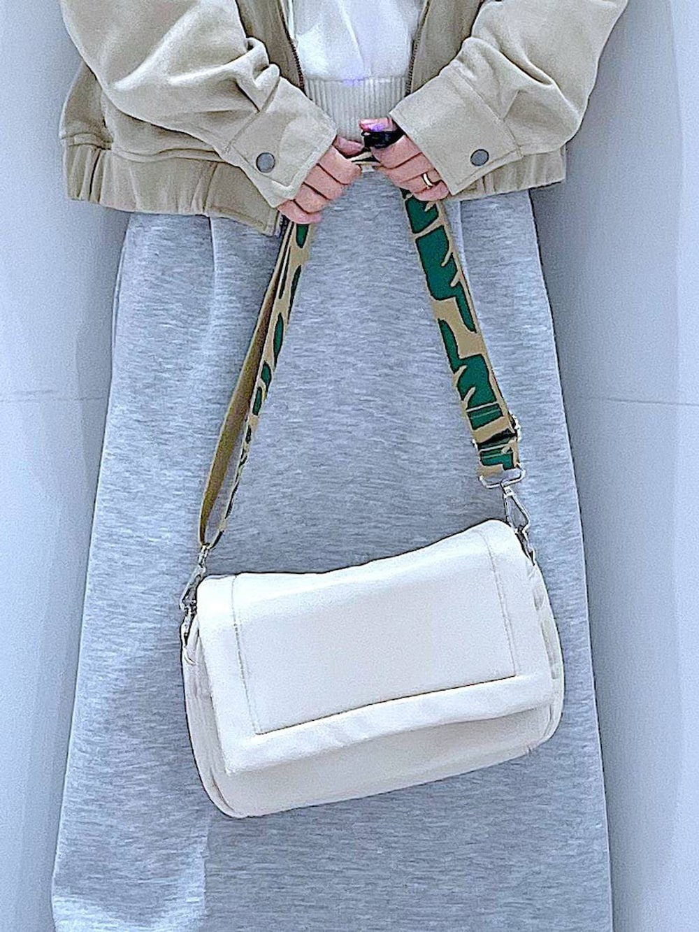 ホワイト系のショルダーバッグ、ベージュ系のニット/セーター、グレー系のスカートを着用したレディースの春コーディネートの9枚目の写真