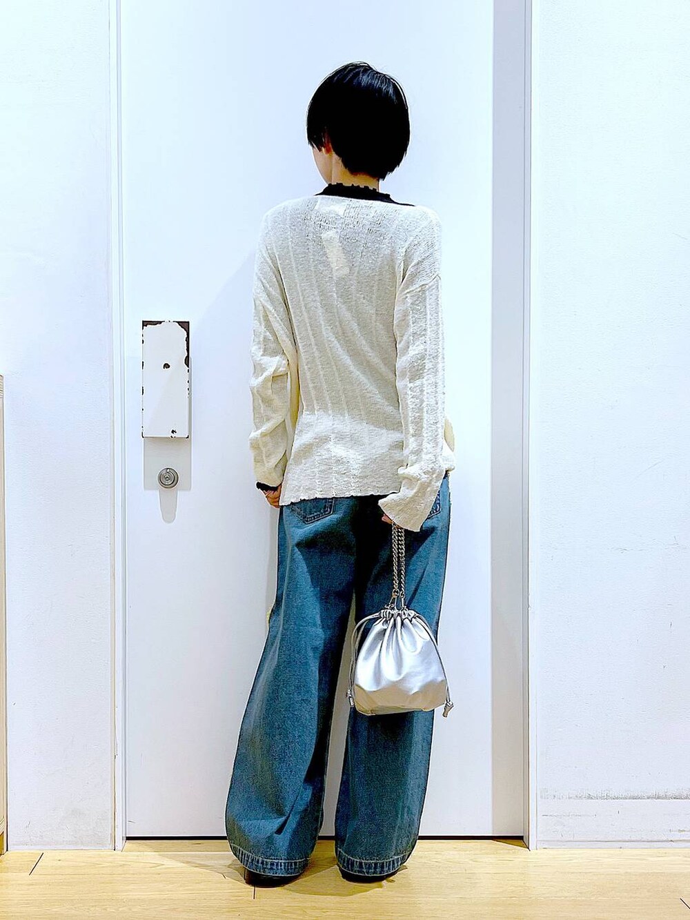 ブラック系のTシャツ/カットソー、シルバー系のショルダーバッグ、ブラック系のスニーカーを着用したレディースの春コーディネートの5枚目の写真