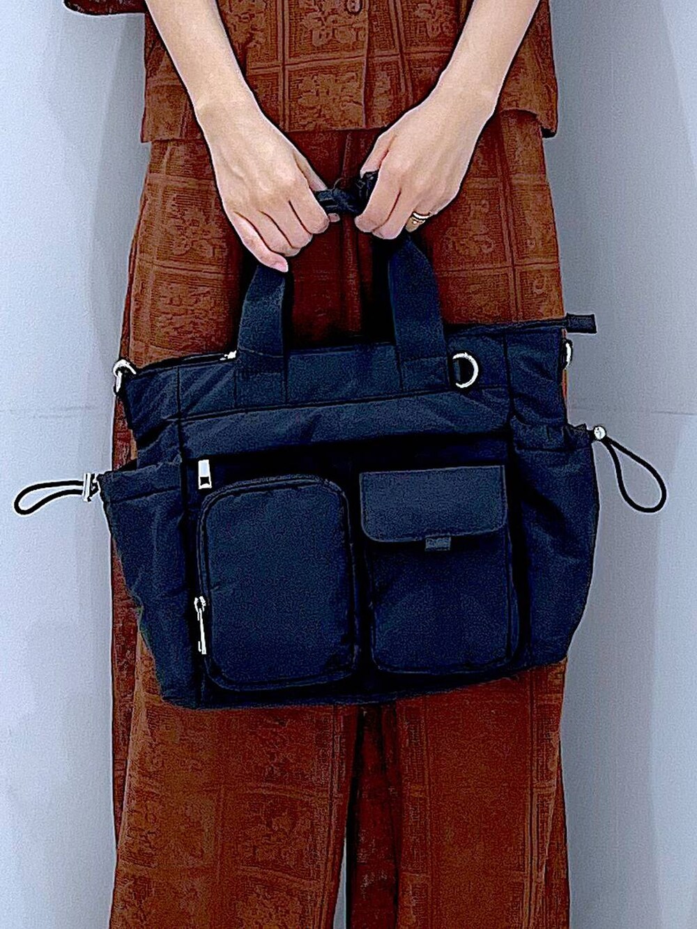 ブラック系のトートバッグ、ブラウン系のシャツ/ブラウス、ブラウン系のその他パンツを着用したレディースの春コーディネートの9枚目の写真