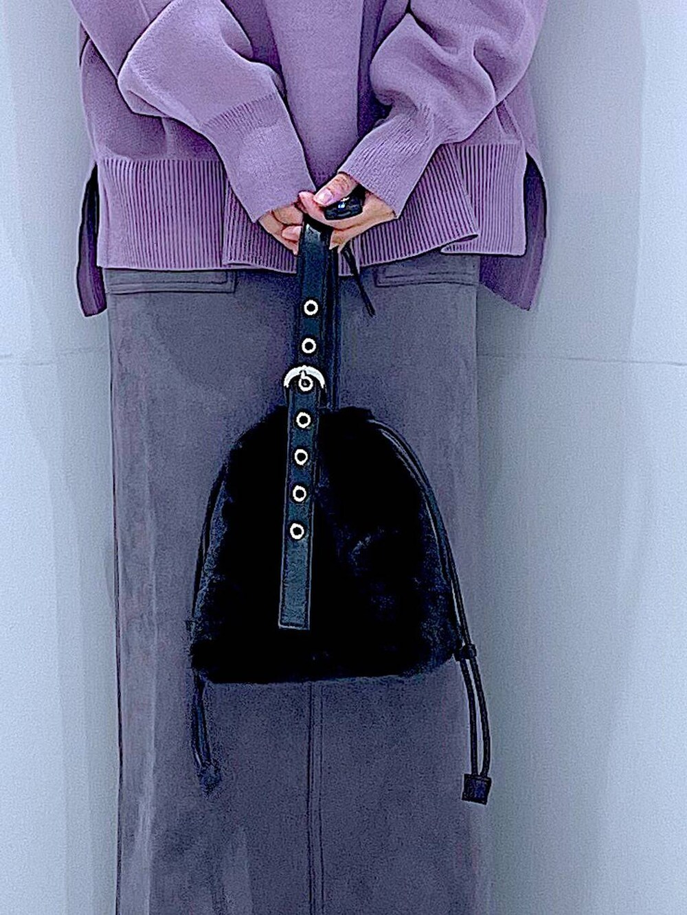 ブラック系のハンドバッグ、ブラック系のブーツ、グレー系のスカートを着用したレディースの冬コーディネートの9枚目の写真