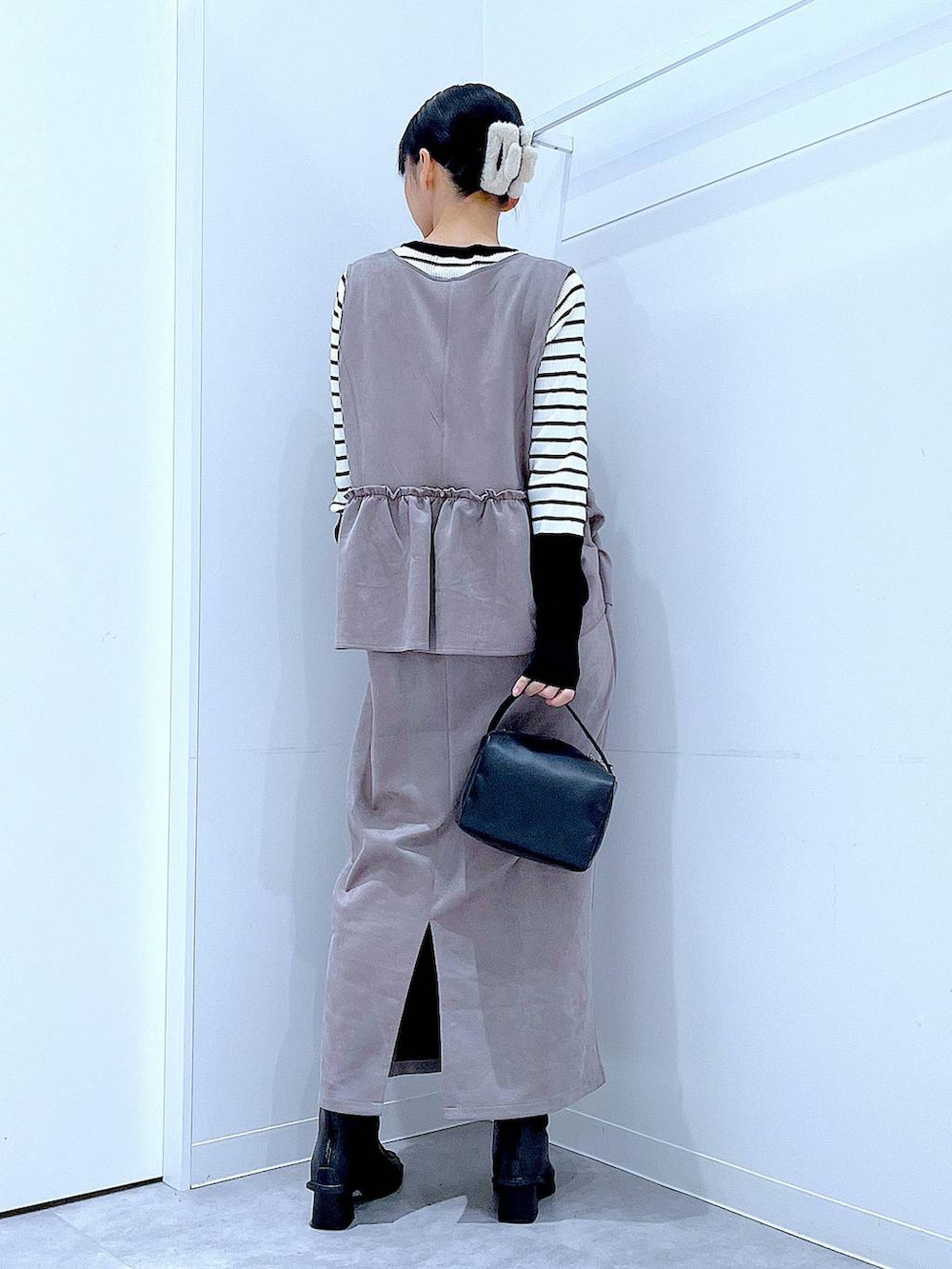 ブラック系のブーツ、グレー系のワンピース、ブラック系のショルダーバッグを着用したレディースの冬コーディネートの5枚目の写真